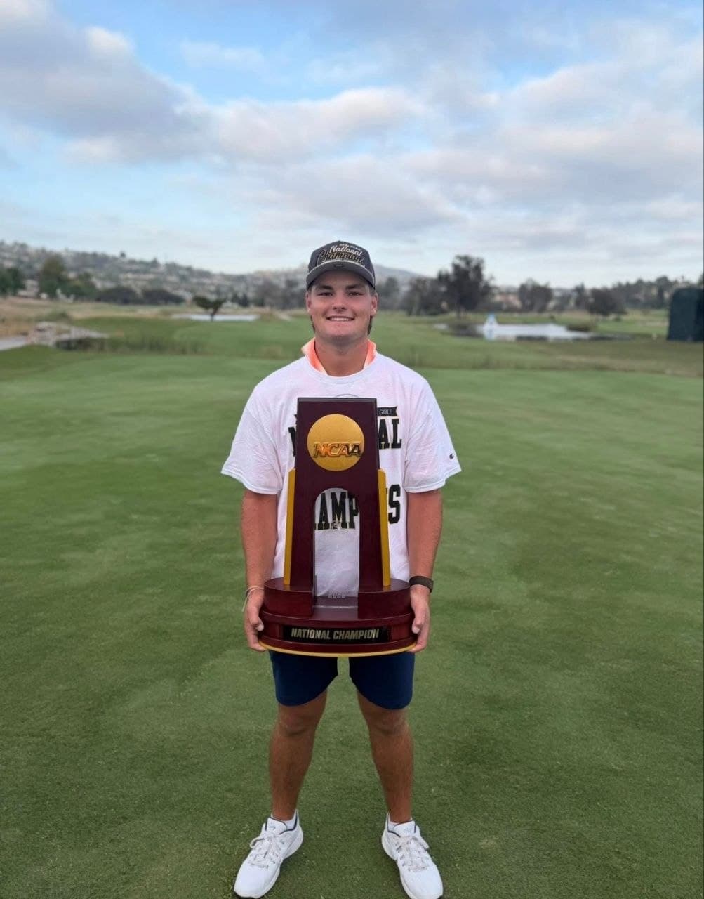 Jake Albert holding the NCAA Division I National Championship trophy on the course